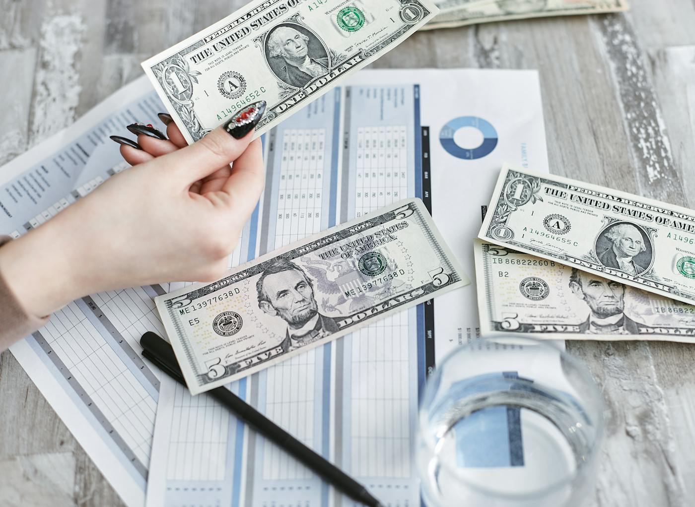 Detail peněz a finančních podkladů jako symbol rozhodování o jednorázové investici.